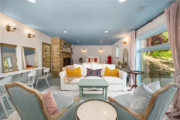 a living room with furniture a fireplace and a large window