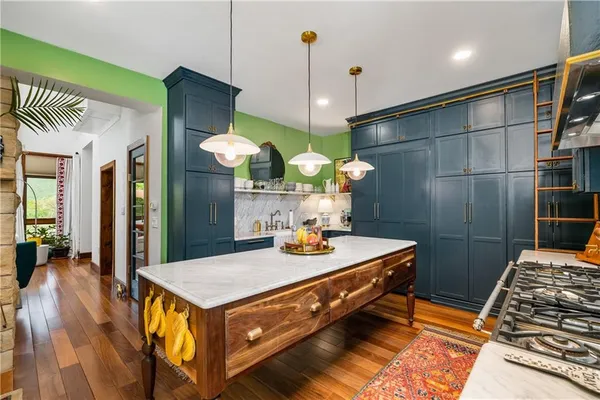 a kitchen with stainless steel appliances granite countertop a stove a sink and a refrigerator