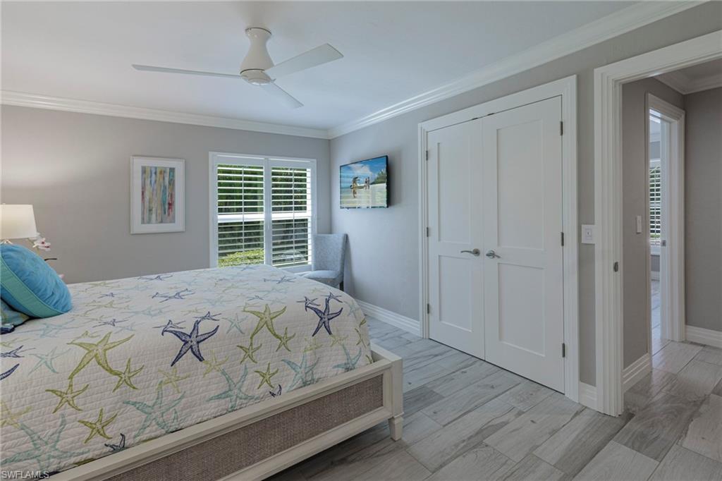 3720 Parkview Way Naples, FL 34103 - Photo 24 of 29 Bedroom featuring light hardwood / wood-style flooring, a closet, ceiling fan, and ornamental molding