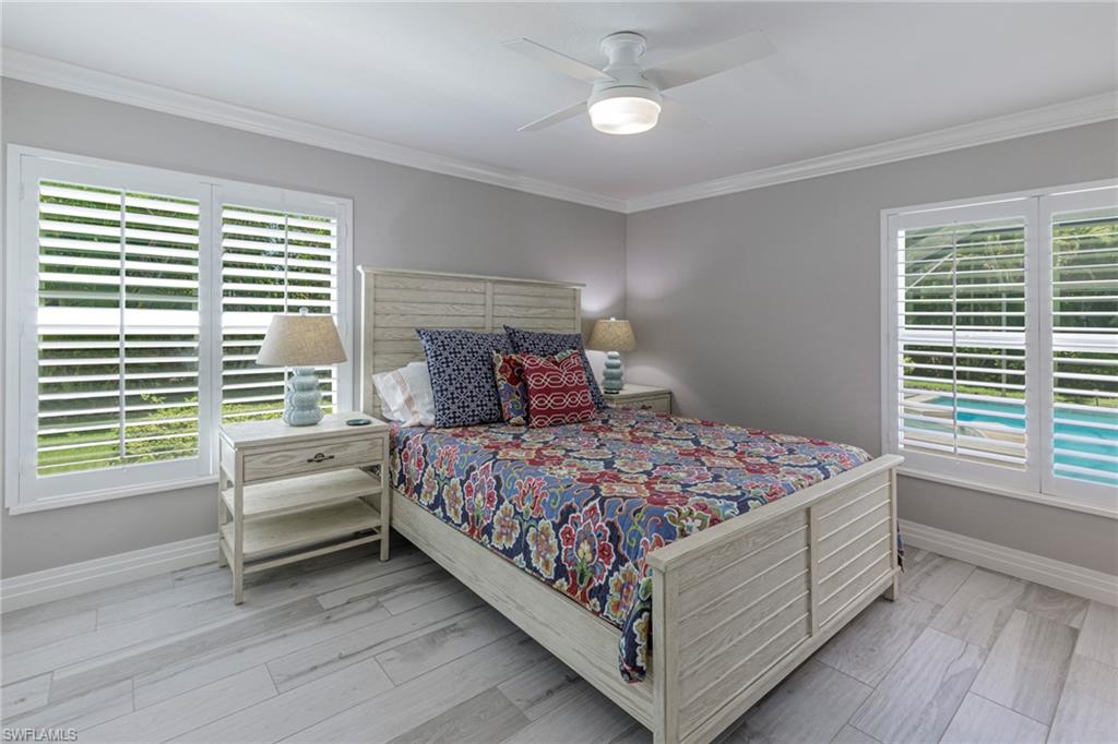 3720 Parkview Way Naples, FL 34103 - Photo 25 of 29 Bedroom featuring ceiling fan, multiple windows, light hardwood / wood-style floors, and ornamental molding