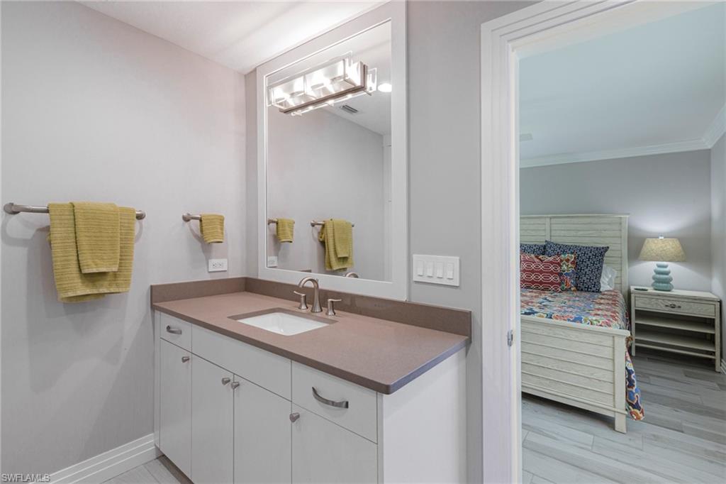 3720 Parkview Way Naples, FL 34103 - Photo 27 of 29 Bathroom with ornamental molding, vanity, and hardwood / wood-style floors