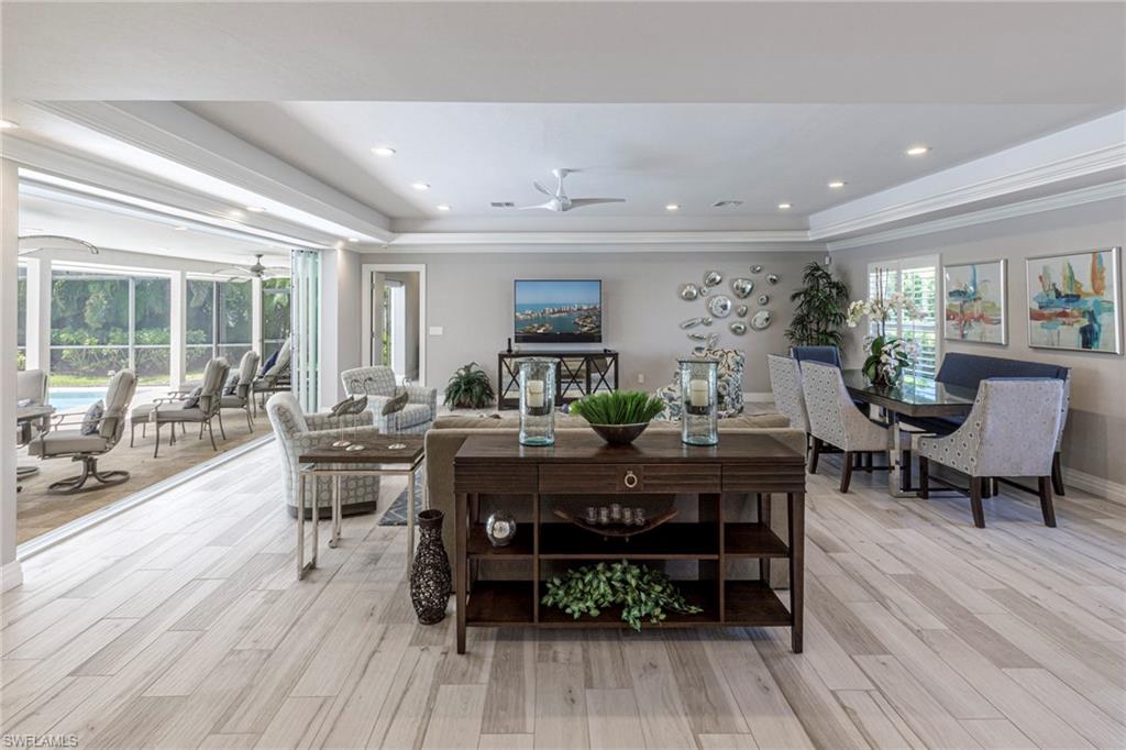3720 Parkview Way Naples, FL 34103 - Photo 3 of 29 Dining room featuring light wood-type flooring, ornamental molding, ceiling fan, and a raised ceiling