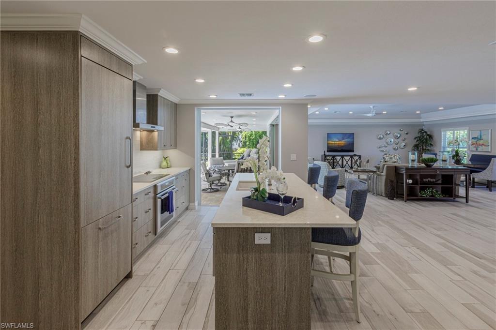 3720 Parkview Way Naples, FL 34103 - Photo 6 of 29 Kitchen featuring a wealth of natural light, oven, light hardwood / wood-style floors, and a kitchen island