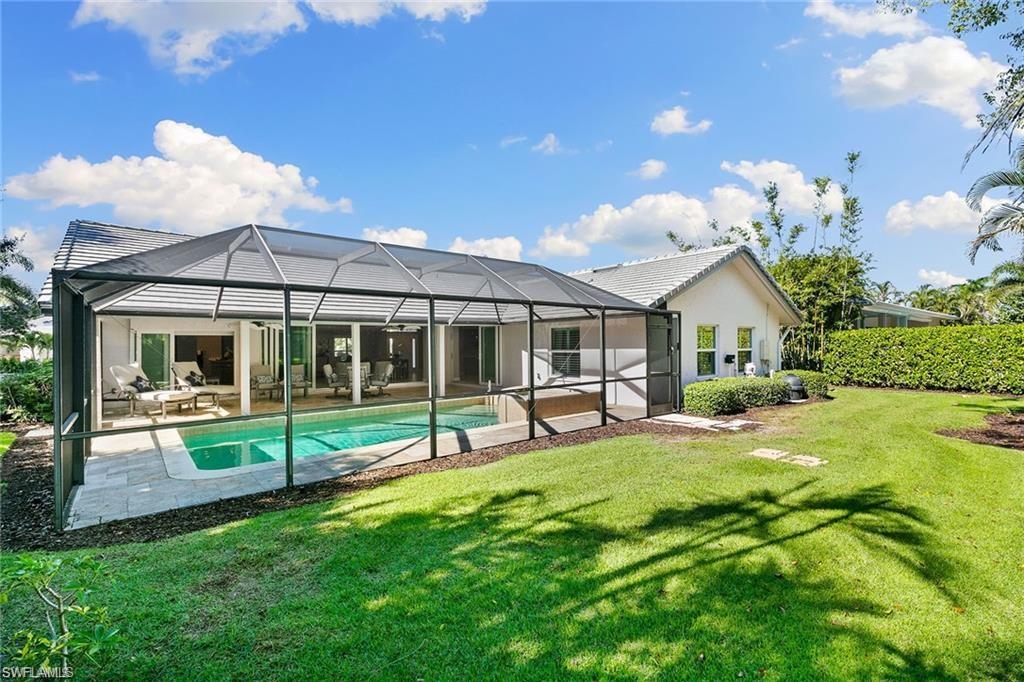 3720 Parkview Way Naples, FL 34103 - Photo 9 of 29 Back of house with a lanai, a fenced in pool, a patio area, an outdoor hangout area, and a lawn