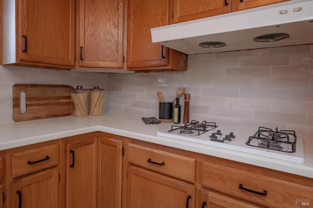 a kitchen with stainless steel appliances granite countertop a sink a stove and cabinets