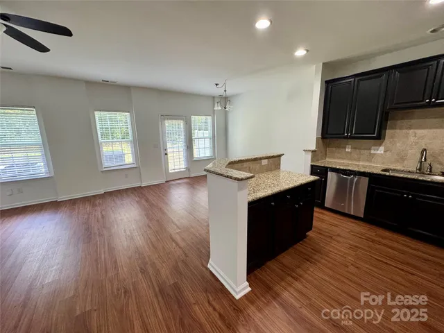 a large kitchen with wooden floors and stainless steel appliances