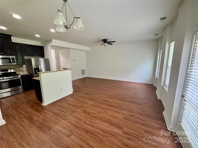 a view of a kitchen with wooden floor and refrigerator