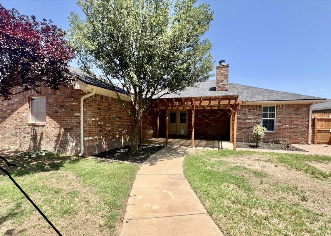 6805 36th Street Lubbock, TX 79407 - Photo 2 of 12 a front view of a house with a yard and garage