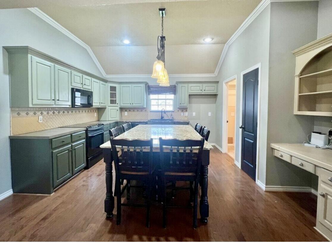 6805 36th Street Lubbock, TX 79407 - Photo 6 of 12 a kitchen with kitchen island a dining table chairs stainless steel appliances and cabinets