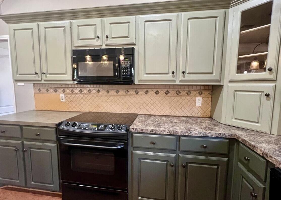 6805 36th Street Lubbock, TX 79407 - Photo 7 of 12 a kitchen with granite countertop white cabinets and stainless steel appliances