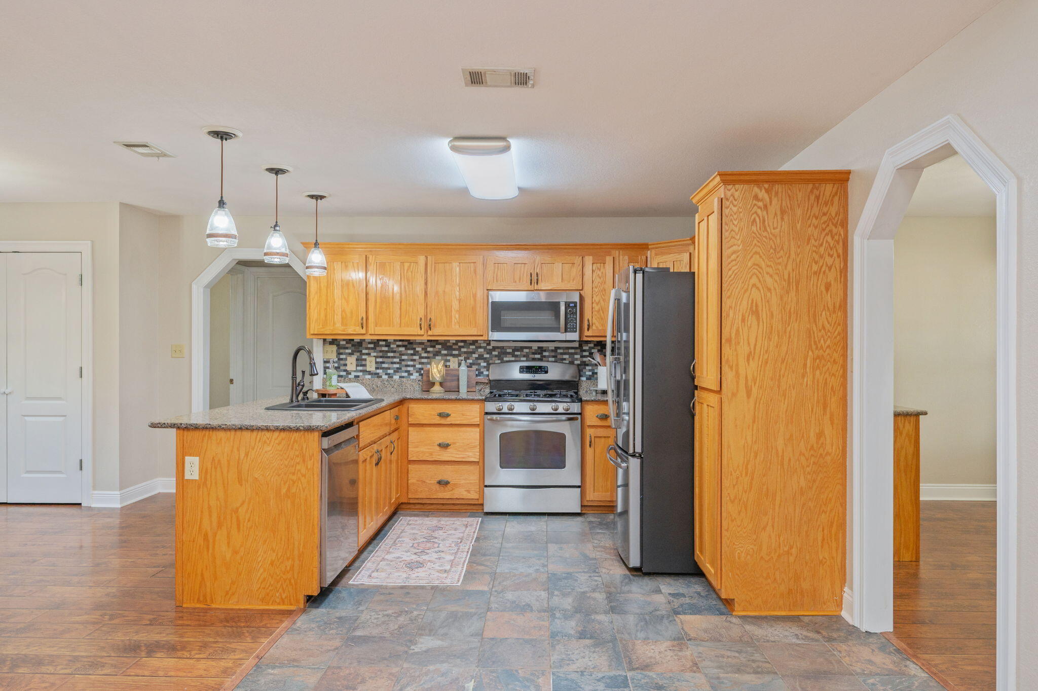 516 Blue Pond Circle Ponce de Leon, FL 32455 - Photo 14 of 39 a large kitchen with stainless steel appliances granite countertop a refrigerator a oven and white cabinets with wooden floors