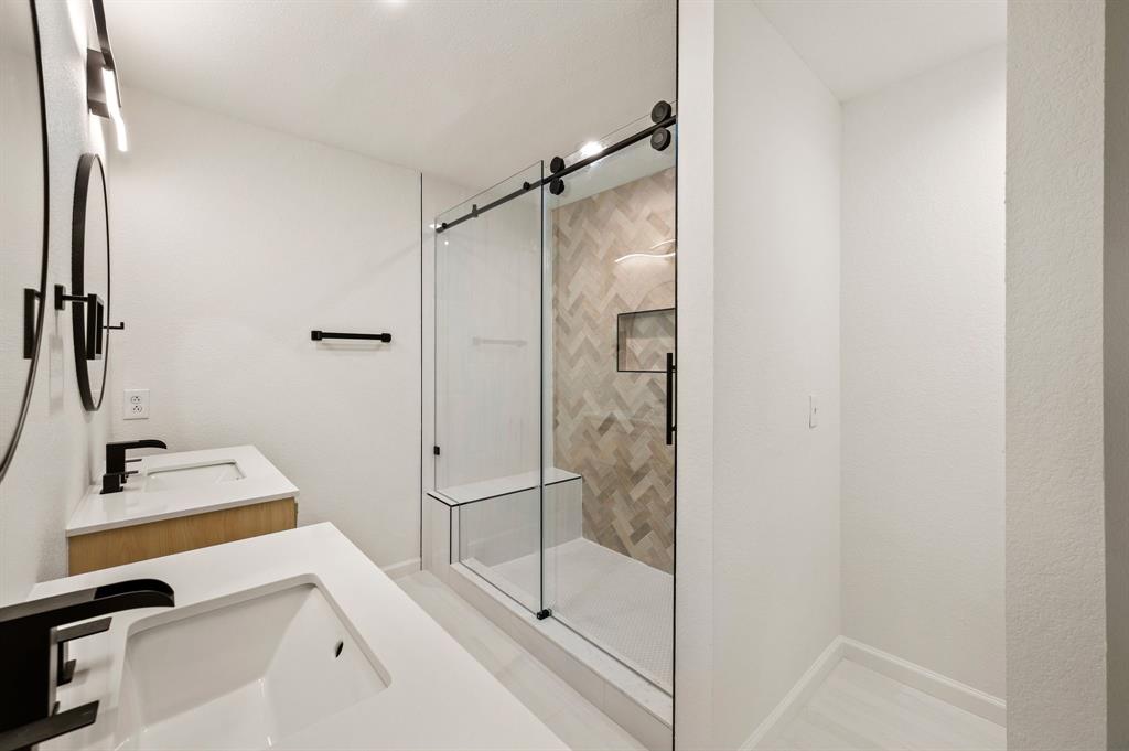 5009 Milam Street Dallas, TX 75206 - Photo 19 of 35 Bathroom featuring two vanities and a shower stall