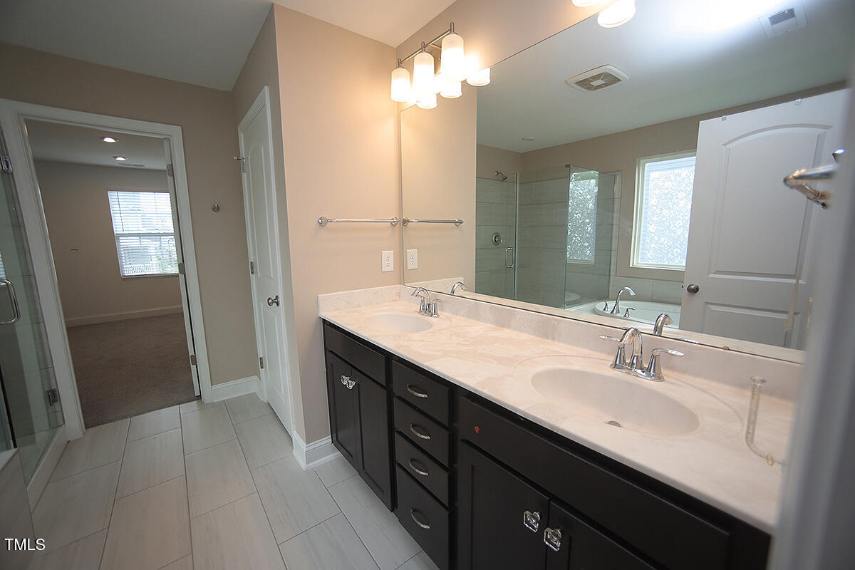 4416 Walker Hallow Street Raleigh, NC 27616 - Photo 19 of 28 a spacious bathroom with a double vanity sink a mirror and a shower