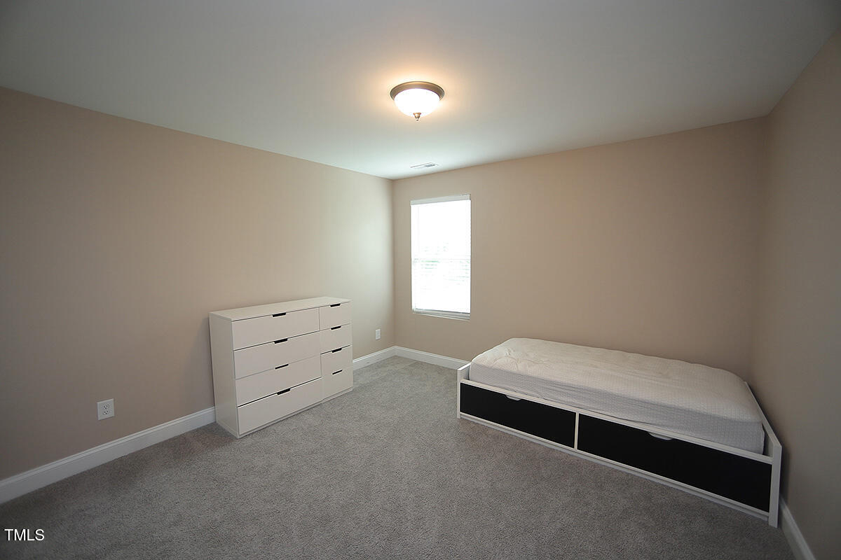 4416 Walker Hallow Street Raleigh, NC 27616 - Photo 23 of 28 a spacious bedroom with a bed and a window