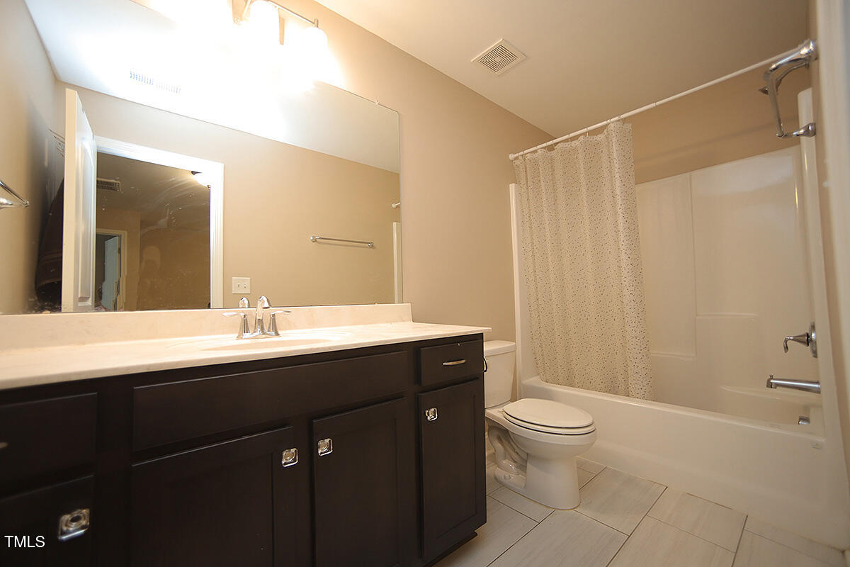 4416 Walker Hallow Street Raleigh, NC 27616 - Photo 24 of 28 a bathroom with a double vanity sink toilet and a mirror