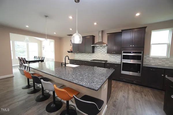 a kitchen with stainless steel appliances granite countertop a stove a sink and a refrigerator