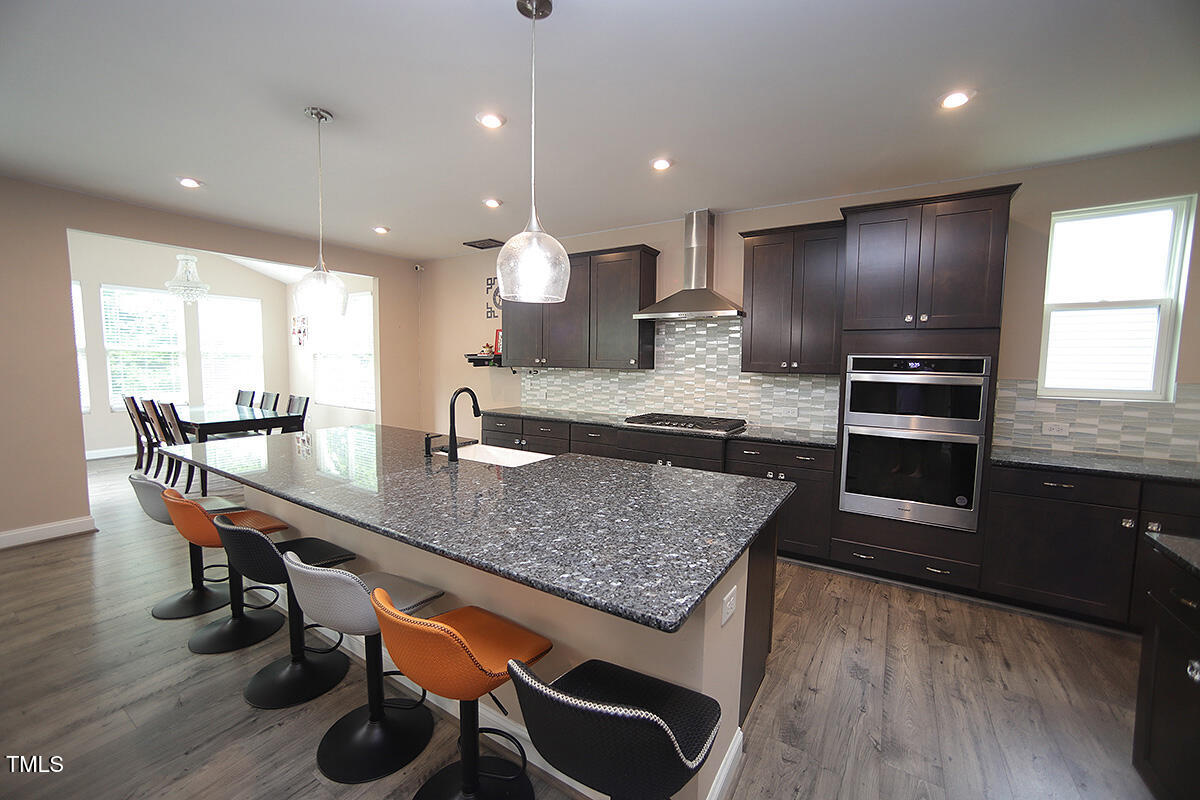 4416 Walker Hallow Street Raleigh, NC 27616 - Photo 7 of 28 a kitchen with stainless steel appliances granite countertop a stove a sink and a refrigerator