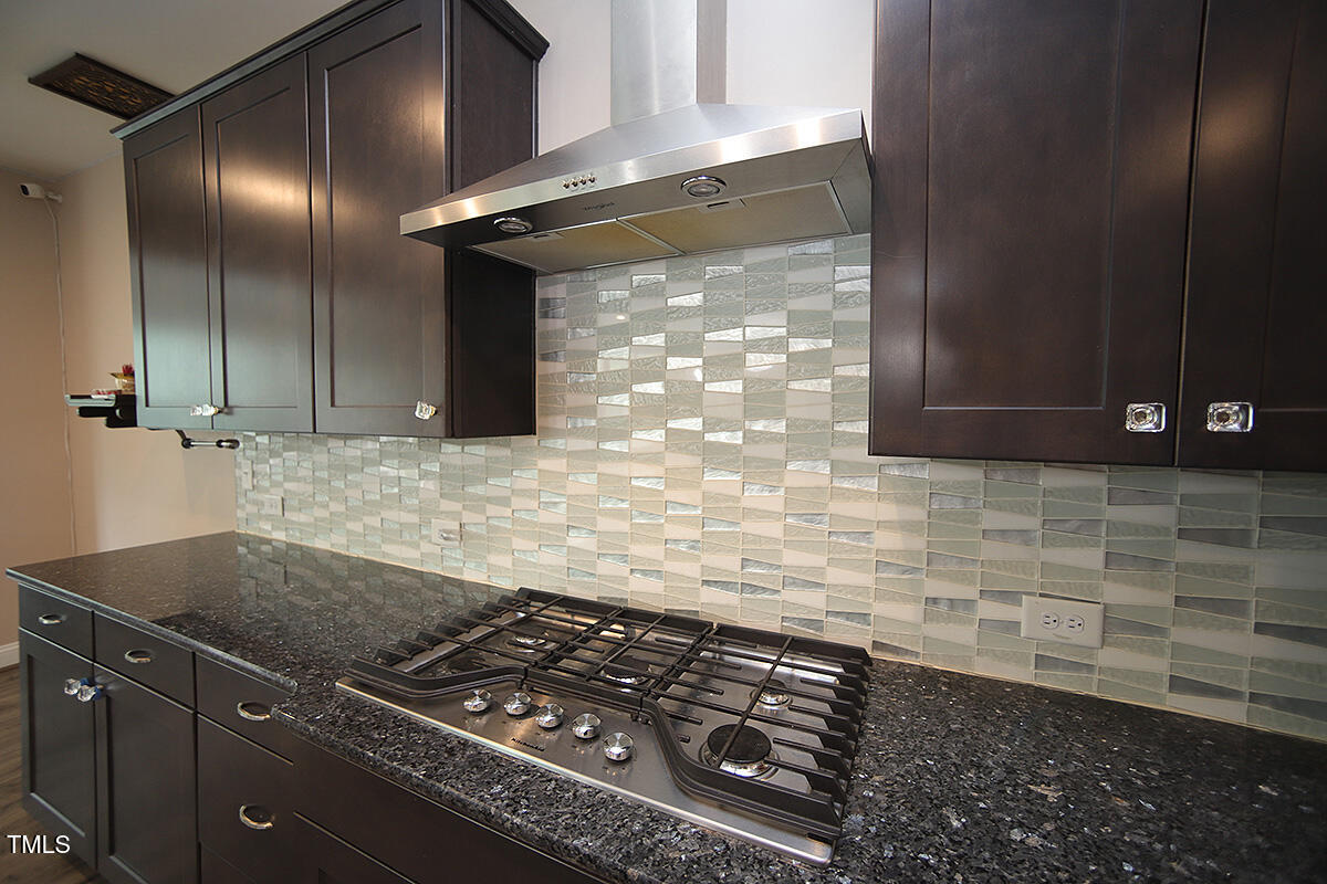 4416 Walker Hallow Street Raleigh, NC 27616 - Photo 9 of 28 a kitchen with granite countertop a stove and a sink