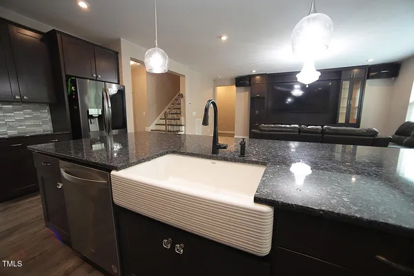 a kitchen with stainless steel appliances kitchen island granite countertop a sink and a refrigerator