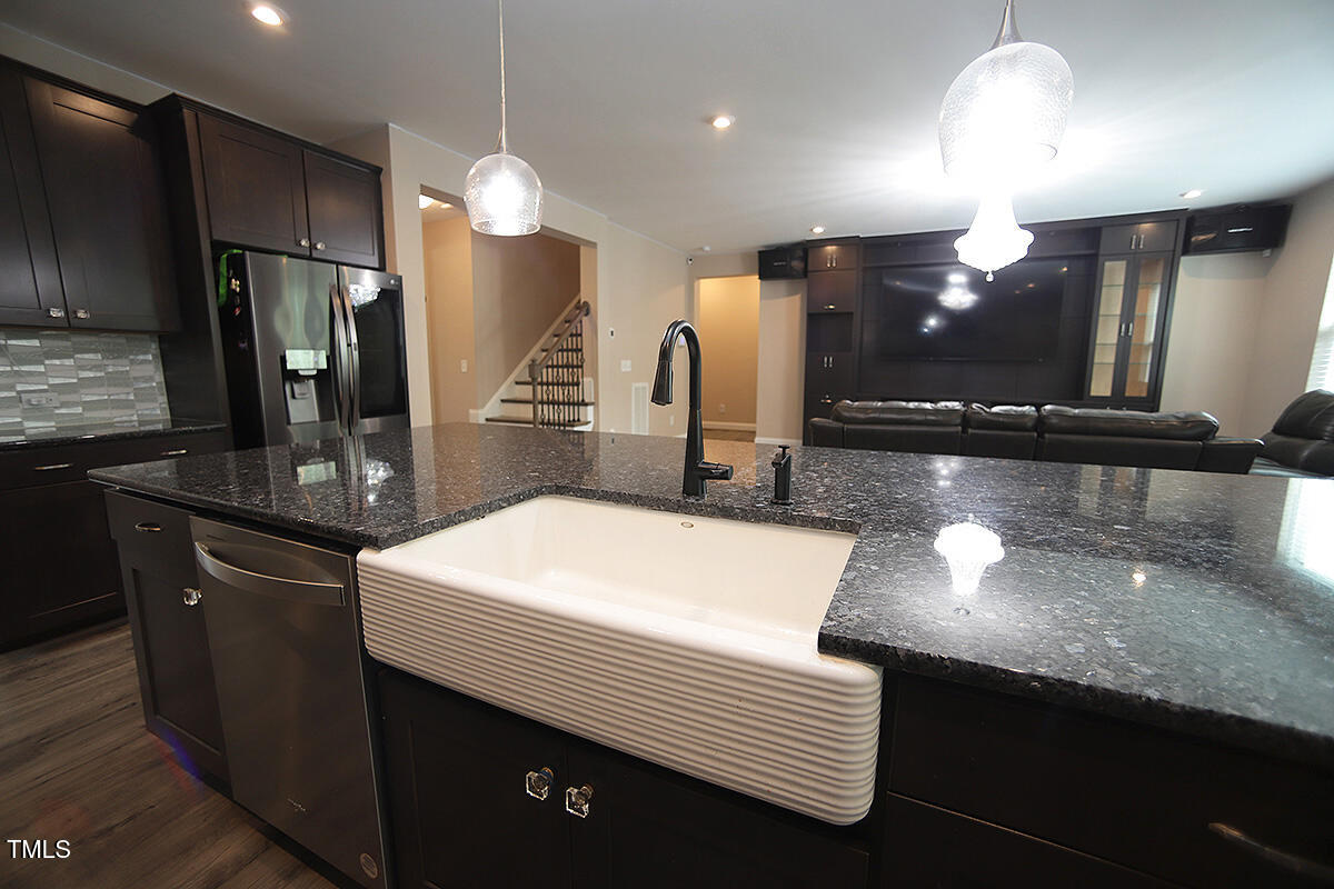 4416 Walker Hallow Street Raleigh, NC 27616 - Photo 10 of 28 a kitchen with stainless steel appliances kitchen island granite countertop a sink and a refrigerator