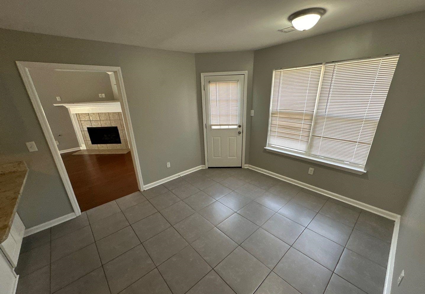 9420 Grove Road Cordova, TN 38016 - Photo 3 of 15 Unfurnished dining area with tile patterned flooring and a tiled fireplace