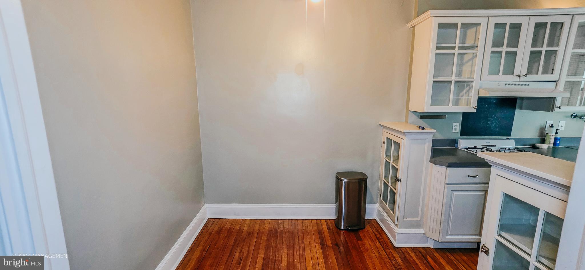 1954 Columbia Road Northwest, Unit 104 Washington, DC 20009 - Photo 11 of 17 a view of a kitchen with fridge and wooden floor
