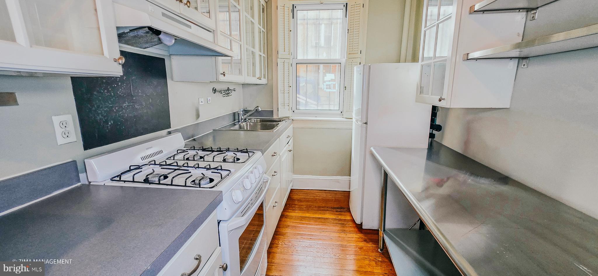 1954 Columbia Road Northwest, Unit 104 Washington, DC 20009 - Photo 13 of 17 a kitchen with stainless steel appliances granite countertop a sink stove and cabinets