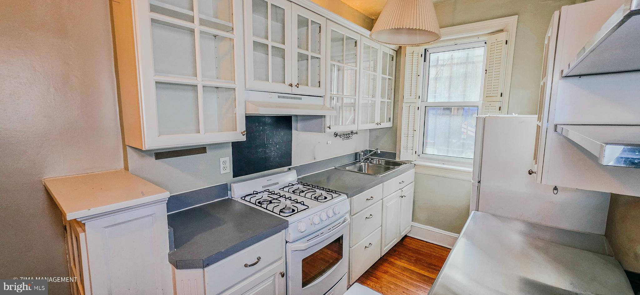 1954 Columbia Road Northwest, Unit 104 Washington, DC 20009 - Photo 14 of 17 a kitchen with stainless steel appliances cabinets a stove and a refrigerator