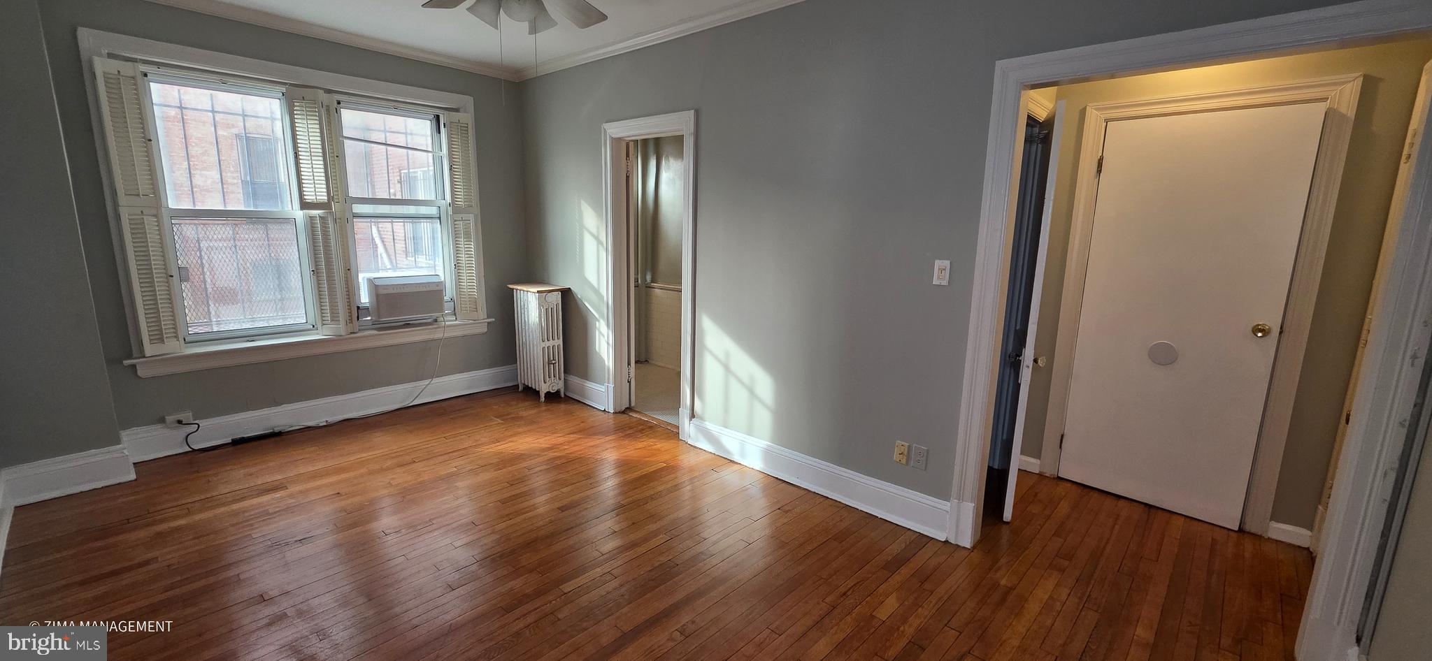 1954 Columbia Road Northwest, Unit 104 Washington, DC 20009 - Photo 6 of 17 an empty room with wooden floor and windows