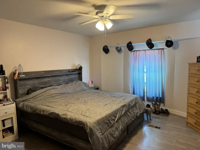 a bed sitting in a bedroom next to a window and a chandelier