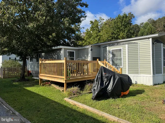 a view of a deck that has a big chair and a big yard with wooden fence