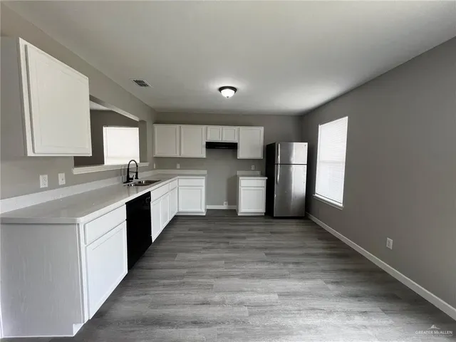 a large kitchen with stainless steel appliances granite countertop a stove a sink dishwasher and a refrigerator