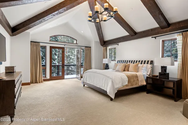 a spacious bedroom with a bed and a large window