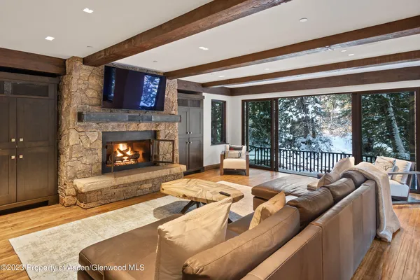 a living room with furniture a flat screen tv and a large window