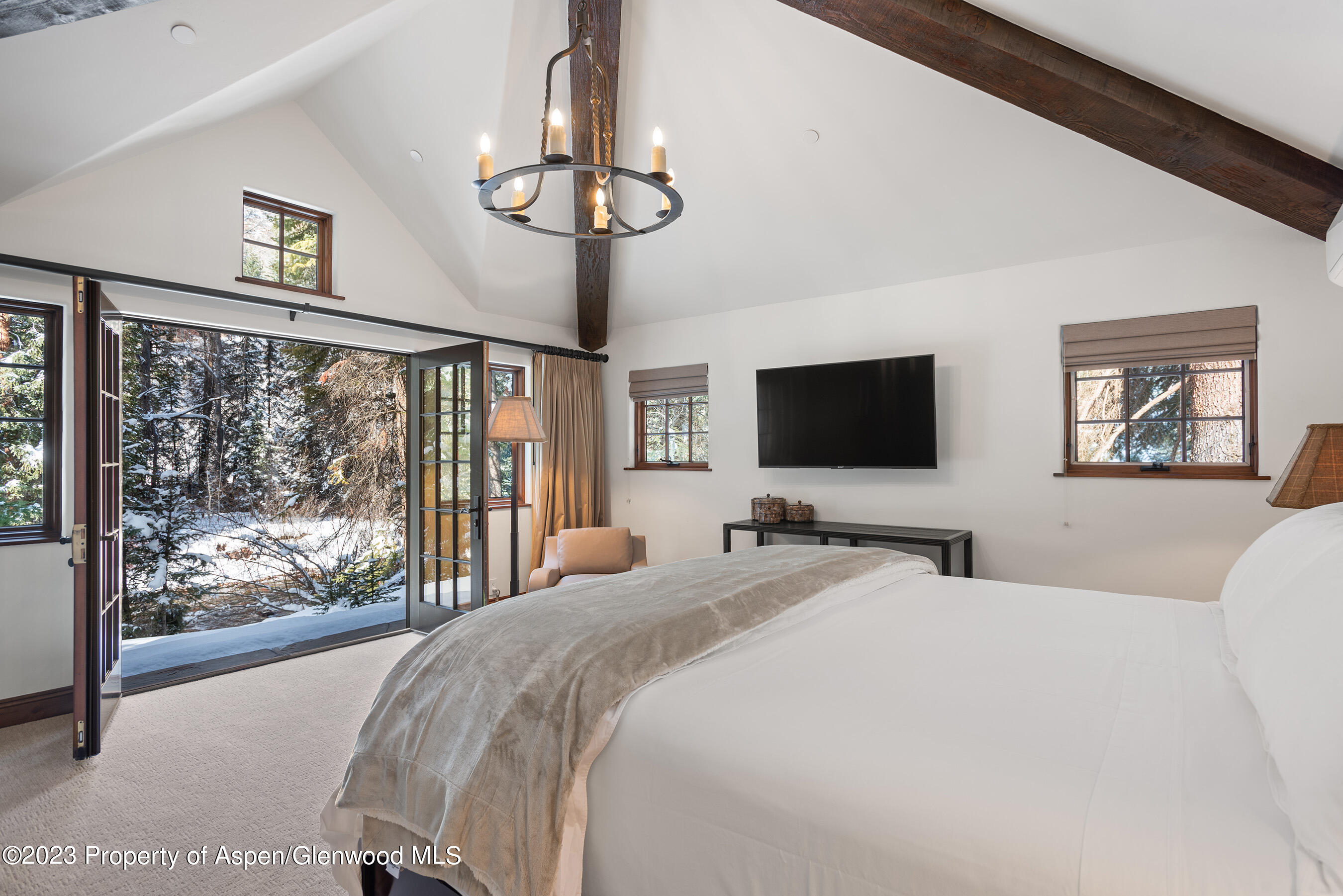 1819 Maroon Creek Road Aspen, CO 81611 - Photo 34 of 43 a bedroom with a large bed and a flat screen tv