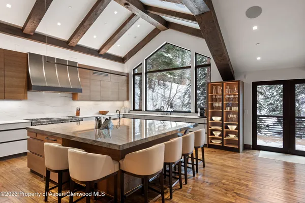 a kitchen with granite countertop a table chairs stove and cabinets