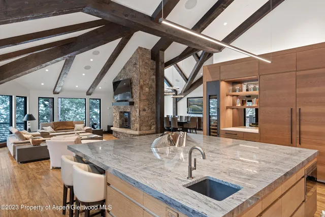 a kitchen with a sink a counter top space and living room filled with furniture