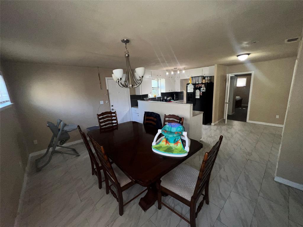 9104 Farmers Road White Settlement, TX 76108 - Photo 21 of 40 Dining area with a chandelier and baseboards