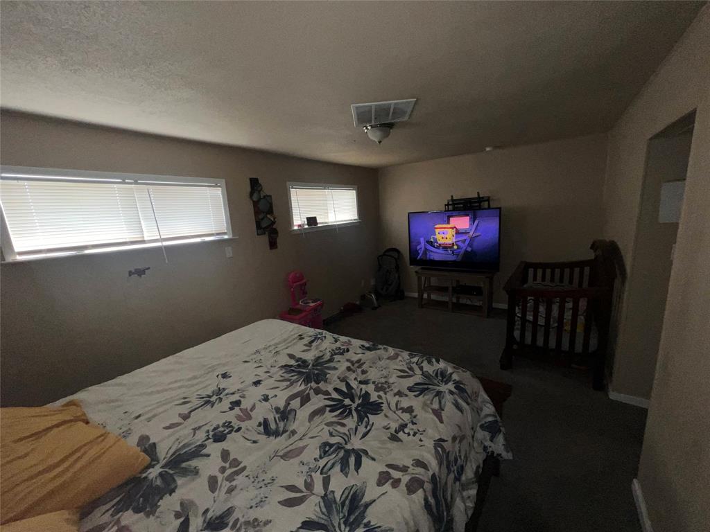 9104 Farmers Road White Settlement, TX 76108 - Photo 7 of 40 Bedroom featuring dark colored carpet and a textured ceiling