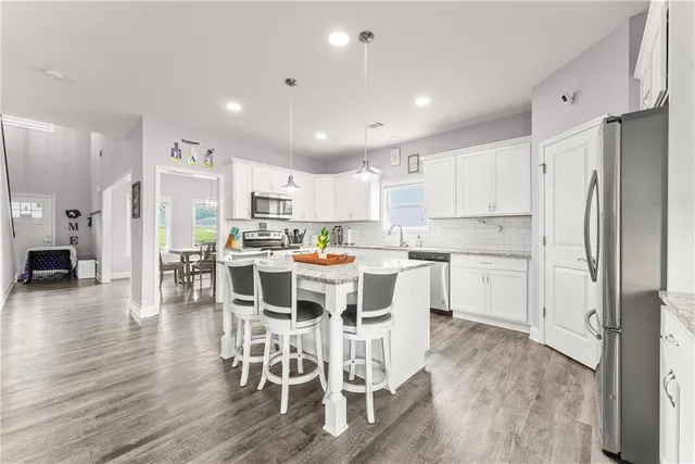 a kitchen with stainless steel appliances a refrigerator a stove top oven and a center island