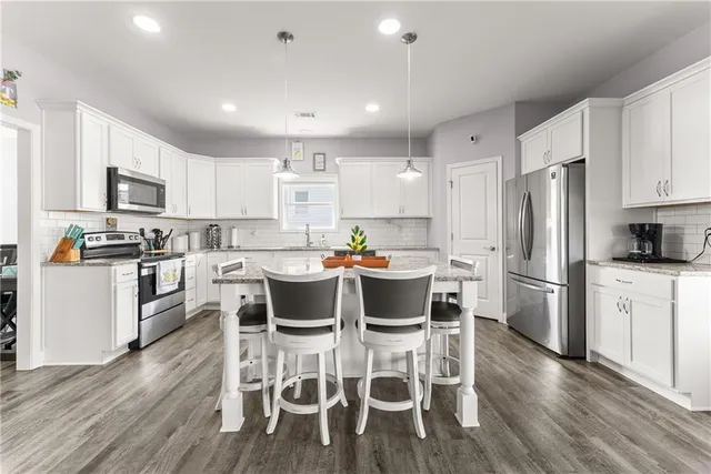 a kitchen with a dining table chairs appliances and cabinets