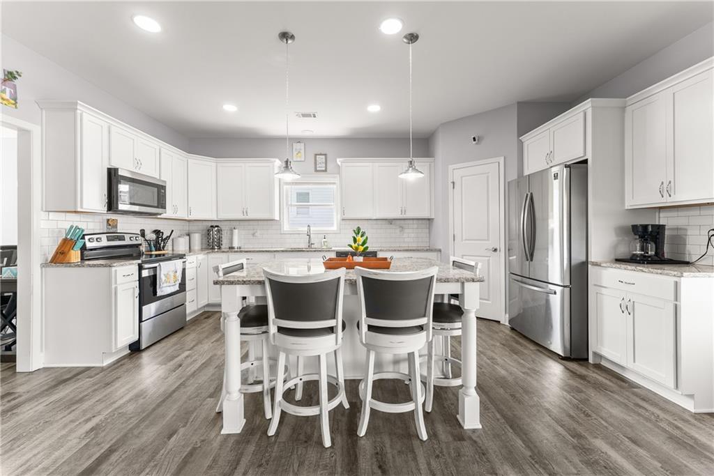 6401 Vista Point Lula, GA 30554 - Photo 12 of 58 a kitchen with a dining table chairs appliances and cabinets