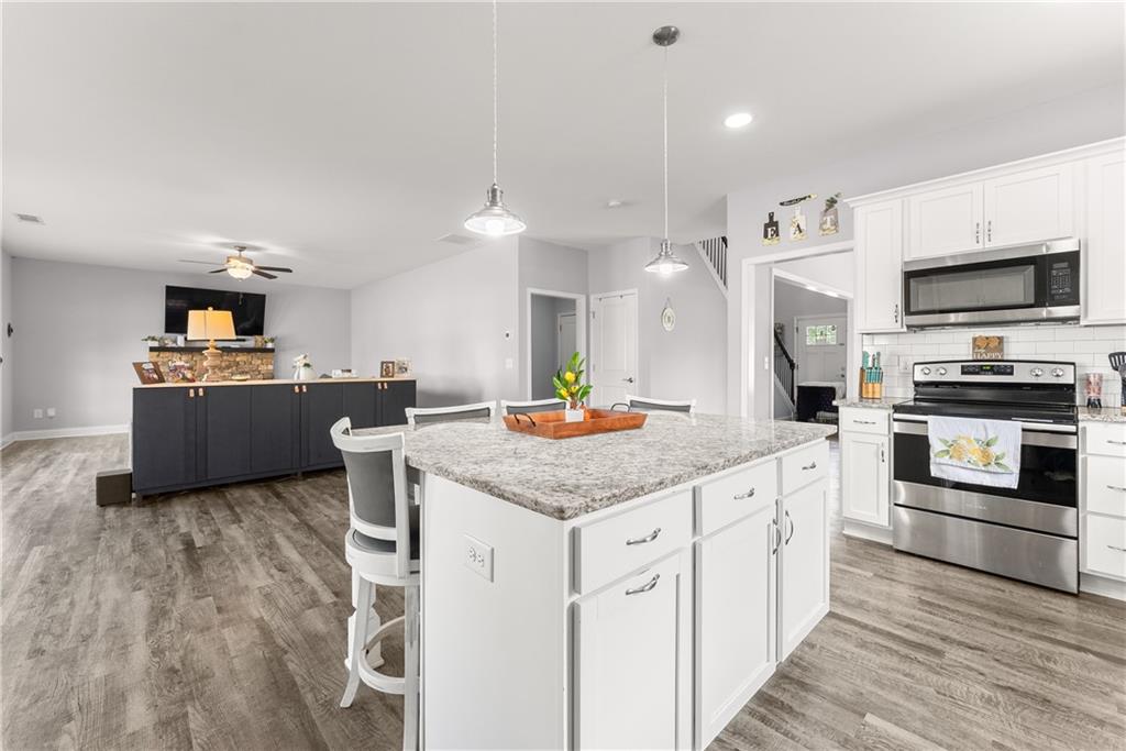 6401 Vista Point Lula, GA 30554 - Photo 14 of 58 a kitchen with stainless steel appliances kitchen island granite countertop a stove a sink and a refrigerator