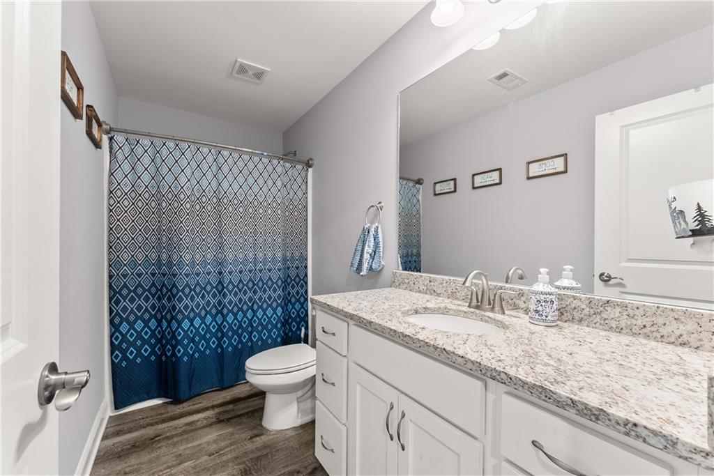 6401 Vista Point Lula, GA 30554 - Photo 24 of 58 a bathroom with a granite countertop sink toilet a mirror and shower
