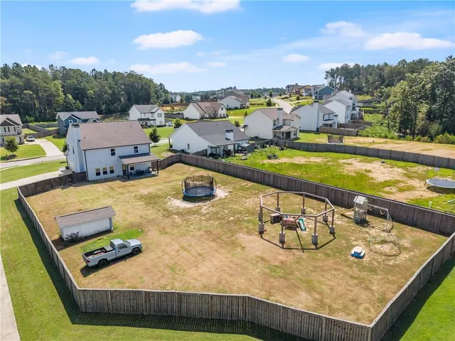 a view of a big house with a big yard and large tree
