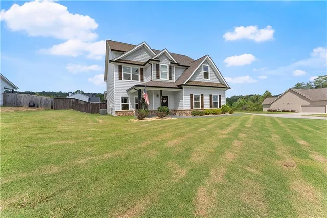 a view of a house with a big yard and large trees
