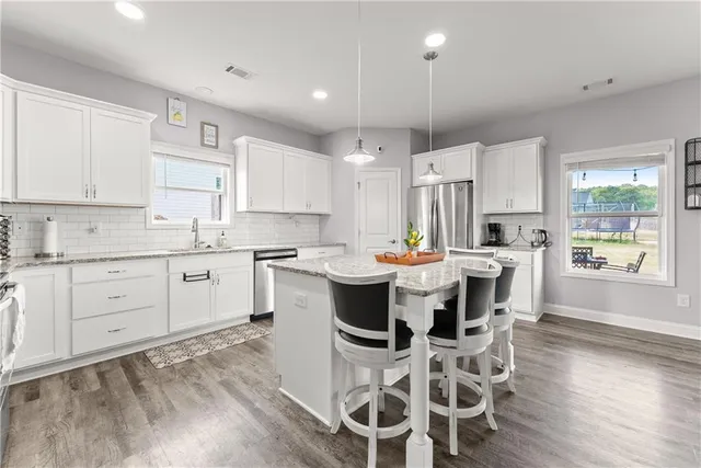 a kitchen with a table chairs refrigerator and cabinets