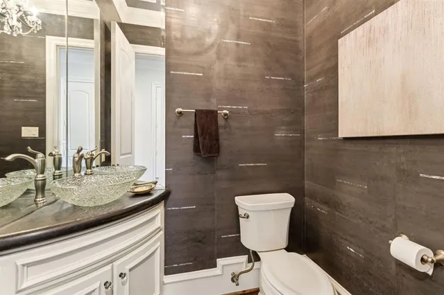 a bathroom with a granite countertop toilet sink and mirror