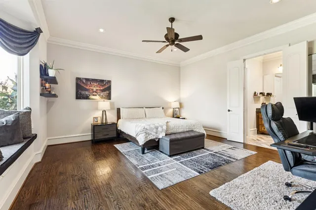 a bedroom with a bed a couch and a dresser with wooden floor