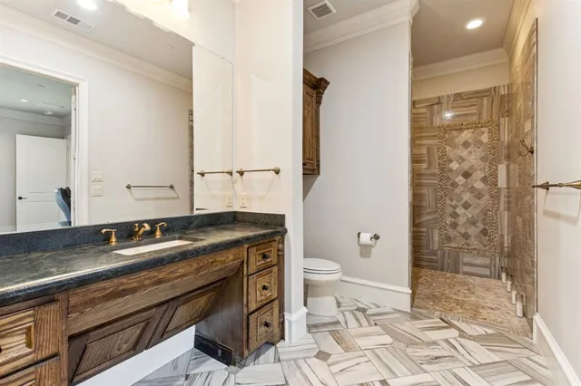 a bathroom with a granite countertop sink a toilet a mirror and shower